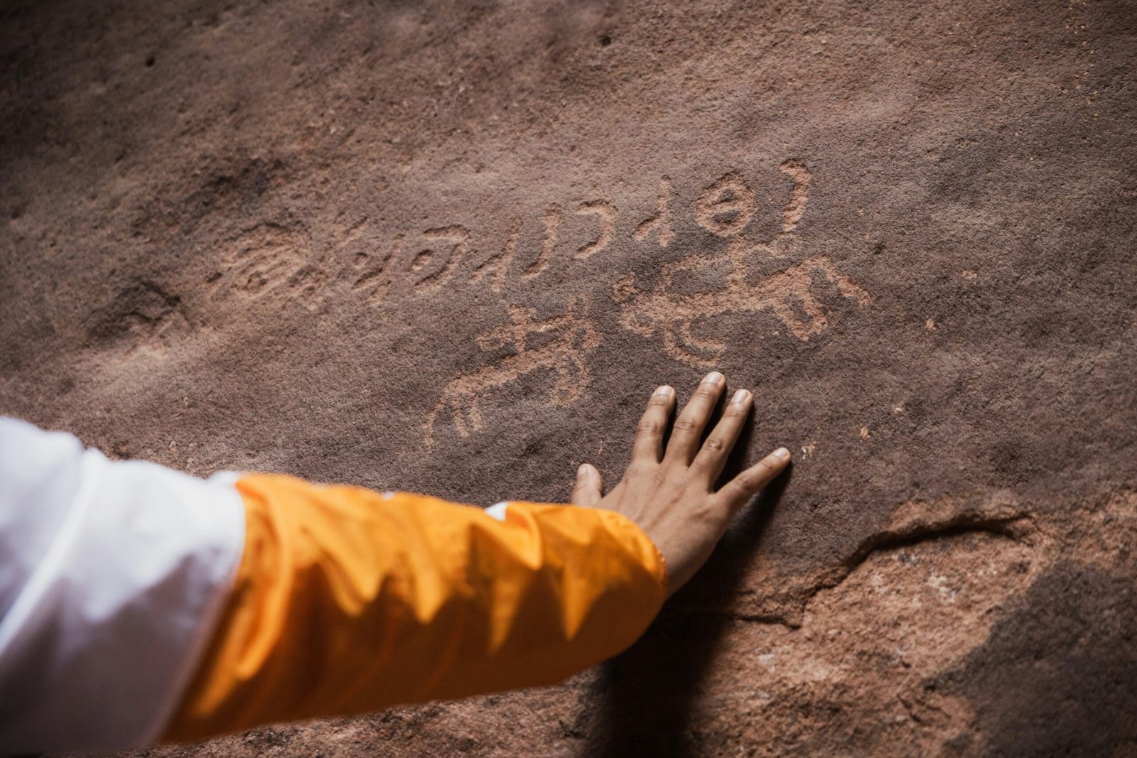 a person with their hand on a rock